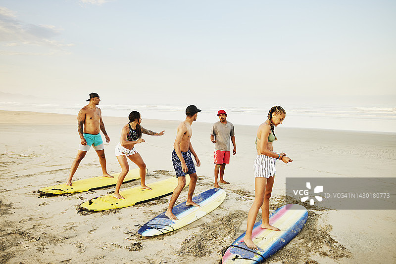 热带海滩上，一家人参加冲浪课程图片素材