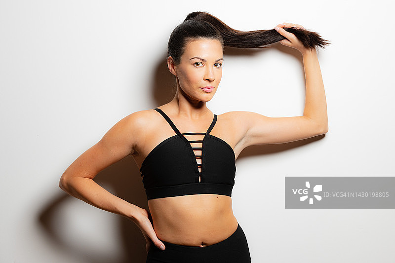 白色背景下的年轻女性健身模特图片素材