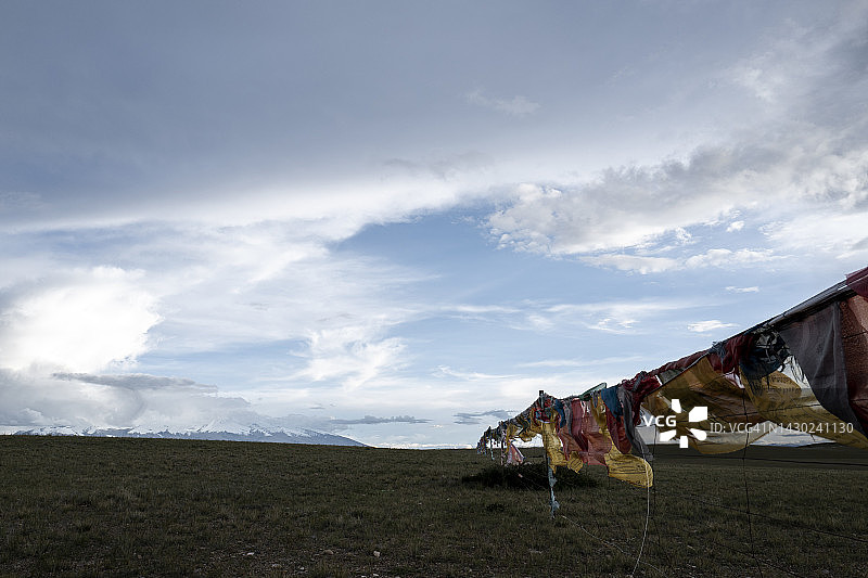 西藏阿里冈仁波齐雪域高原变幻云彩下的祈祷旗图片素材
