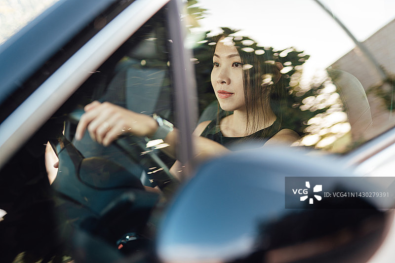 表情严肃的年轻亚裔女性开车图片素材