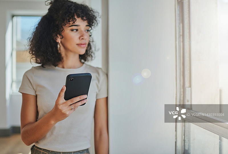 商务女人在办公室窗边使用手机思考图片素材