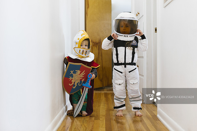 （2-3岁）装扮成骑士的幼儿和装扮成宇航员的女孩在家玩耍图片素材
