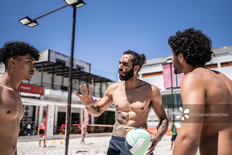 教练在沙滩排球课上与运动员交谈图片素材