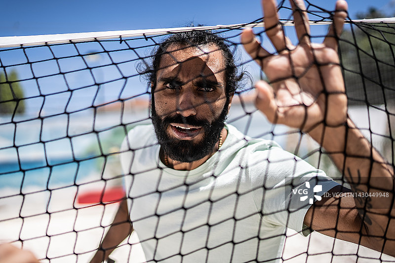 手持沙滩网球网的中年男人肖像图片素材