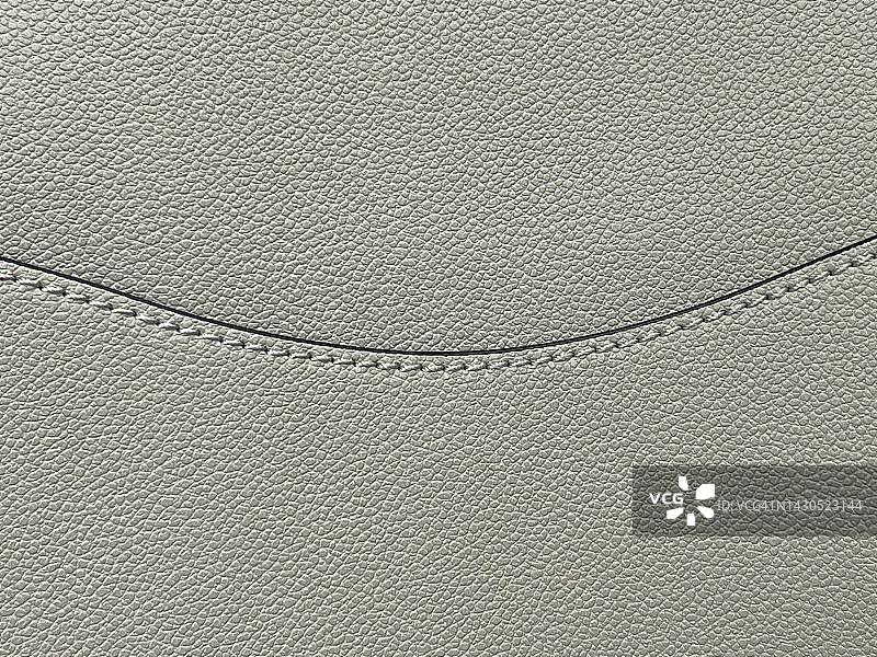 米褐色手提包的局部，展示纹理和缝线图片素材