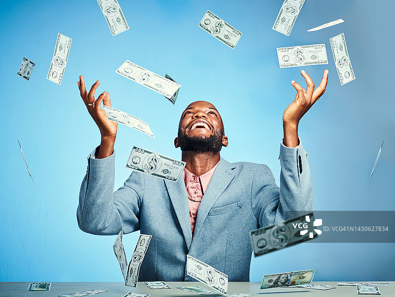 黑人男子，金钱赢家和成功庆祝，在蓝色背景工作室庆祝金融增长、投资和储蓄预算。微笑、快乐和兴奋的金融工作者，拥有股市交易现金图片素材