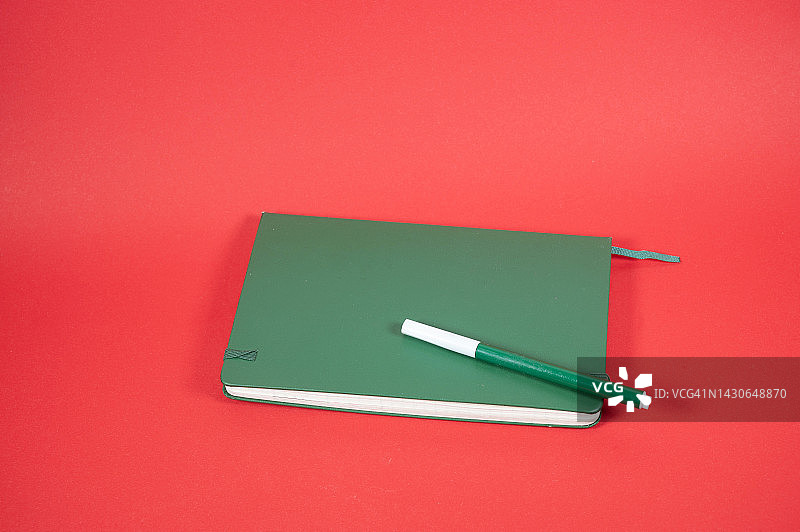 学生笔记本上的笔，红色背景图片素材