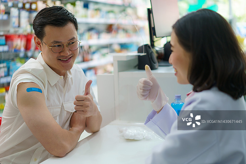 亚洲男人在药店接受疟疾、破伤风、伤寒、肝炎疫苗，准备旅行图片素材