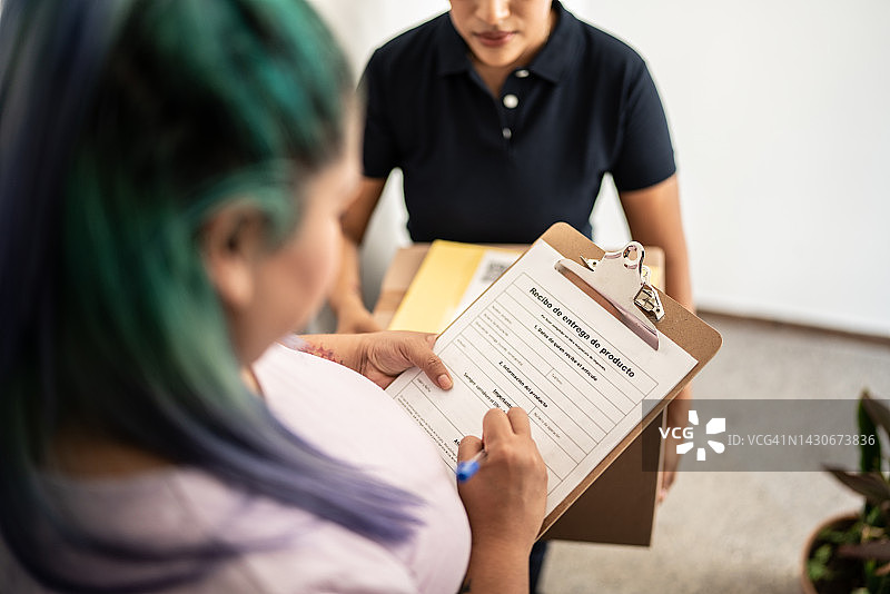女性在家门口签署收货文件特写图片素材
