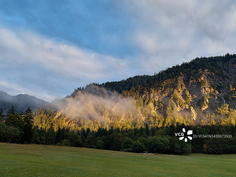 阳光洒在山脉上，欧洲阿尔卑斯山的秋色图片素材