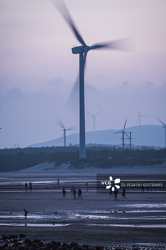 靠近海滩的大型风力涡轮机农场图片素材