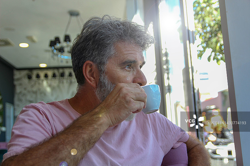 在咖啡馆里使用手机的年长男人图片素材