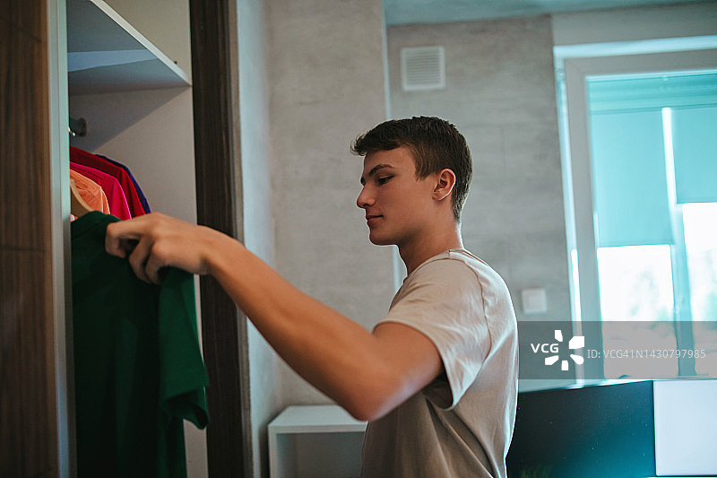 青少年男孩整理他的衣橱图片素材