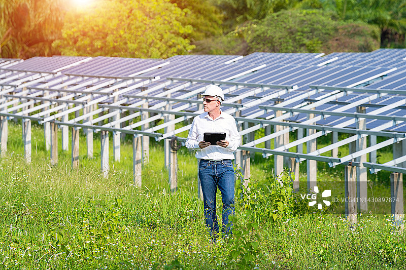 工程师检查太阳能电池板、太阳能电池和太阳能发电场图片素材