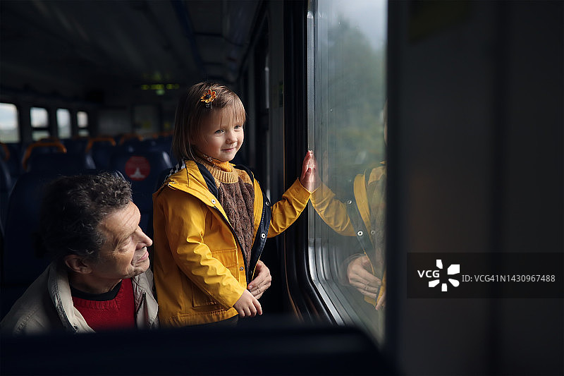 快乐的孩子和中年父亲在火车上欣赏风景图片素材