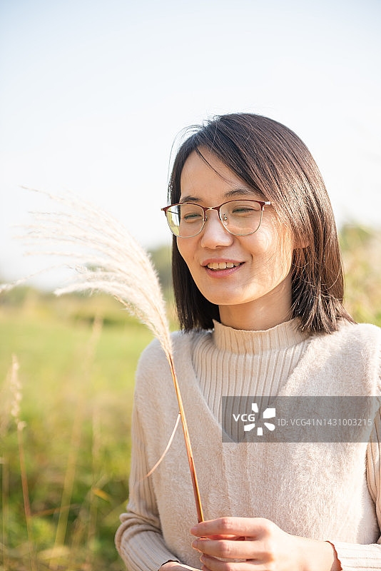 手持白色蓬松花朵的美丽女人图片素材
