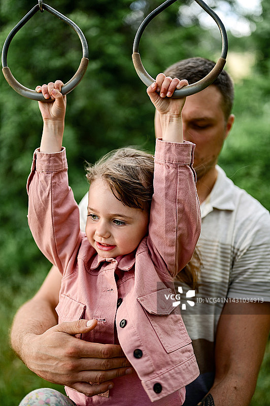 孩子喜欢在操场上玩单杠图片素材