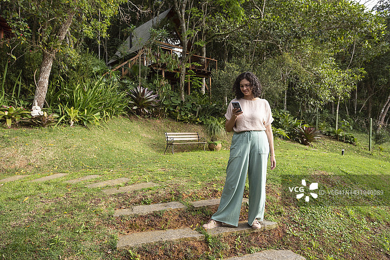 在开放式花园里使用手机的拉丁裔女人图片素材