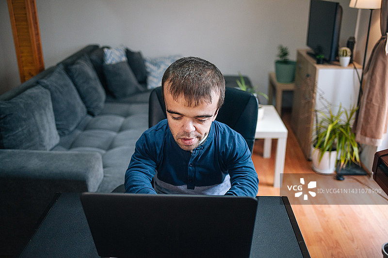 在家工作的患有侏儒症的年轻男人图片素材