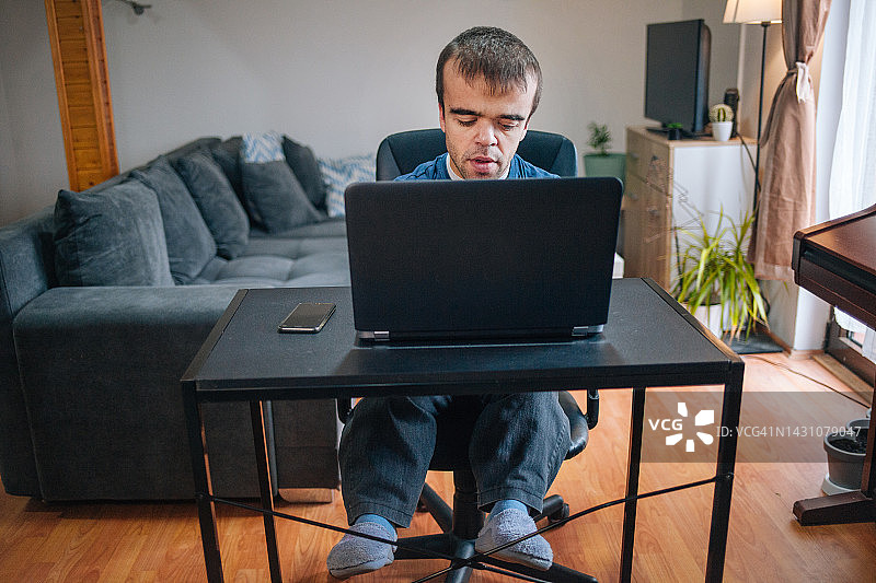在家工作的患有侏儒症的年轻男人图片素材