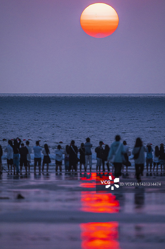旅行者在海滩上看日出图片素材