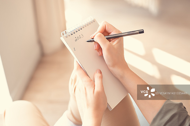 女士手部特写，拿着记事本和笔。2023新年计划图片素材