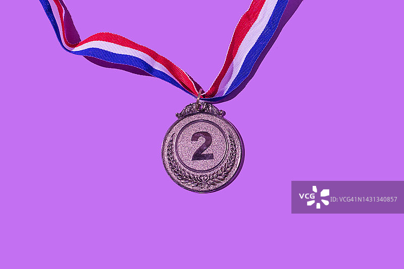 紫色背景上的银牌，数字为2，代表第二名，获胜者、奖牌、荣誉、妇女节、获胜女性、职场女性和体育竞赛概念图片素材