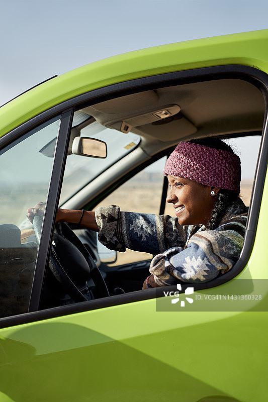 竖版驾驶绿色货车自驾游的美丽自信年轻女人照片图片素材