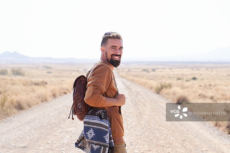 沙漠公路上的英俊金发男人，看向镜头图片素材