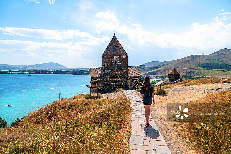 女孩在亚美尼亚的塞凡湖畔走向塞凡纳旺克修道院图片素材