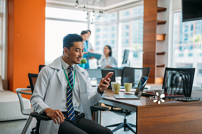 男医生使用智能手机上的医疗应用图片素材