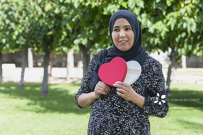 手捧心形礼盒的阿拉伯女人图片素材