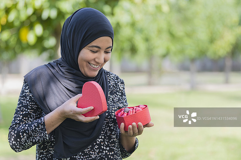 穆斯林妇女拿着浪漫的糖果礼品盒图片素材