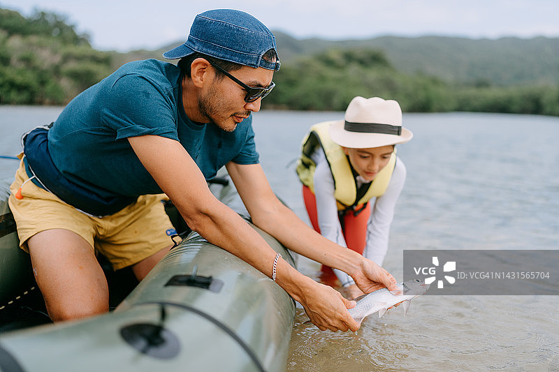 父女放生捕到的鱼图片素材