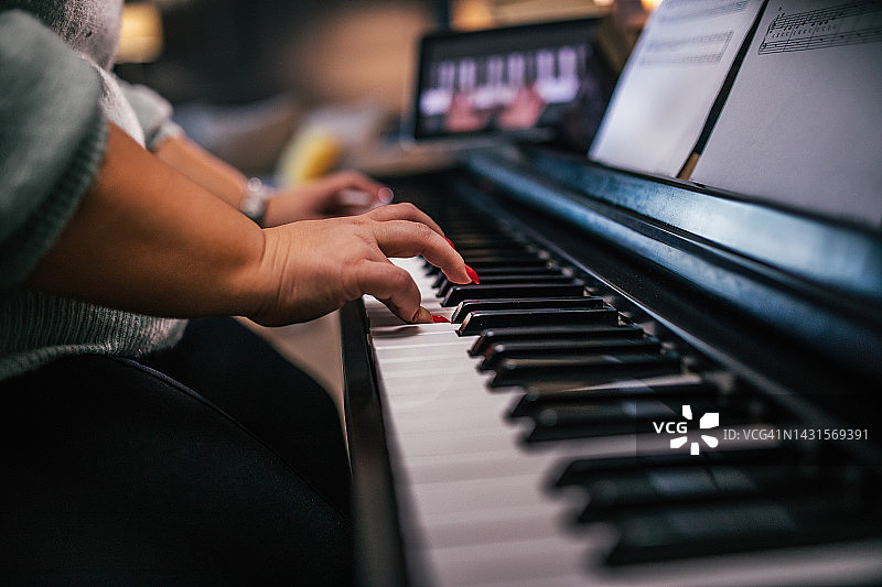 年轻女人弹钢琴并在线教学图片素材