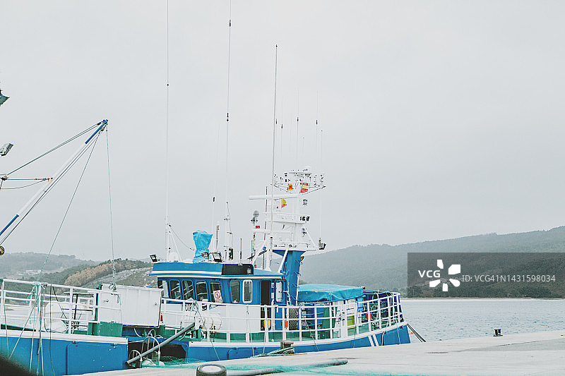 停靠在西班牙加利西亚蓬特韦德拉Rias Baixas混凝土码头的渔船图片素材