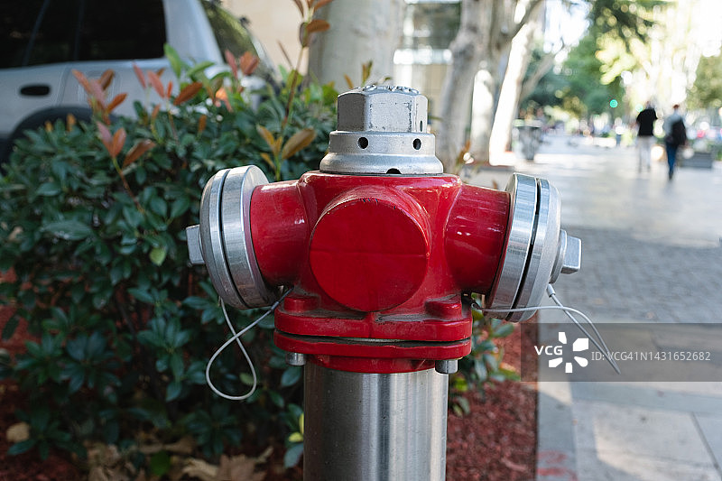 佐治亚街上的红色冷水消防栓，靠近住宅区的一所房子。用于灭火的起重机，室外。安全系统，预防措施。消防安全规则。供水喷淋系统。街道消防起重机。图片素材