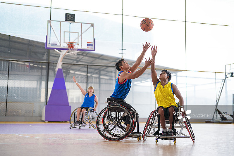 坐轮椅的残疾篮球运动员在球场上打篮球图片素材