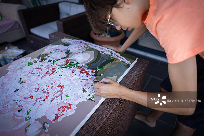 年轻且有创意的男孩在家在画布上绘画图片素材
