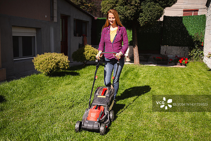 女人在后院割草图片素材