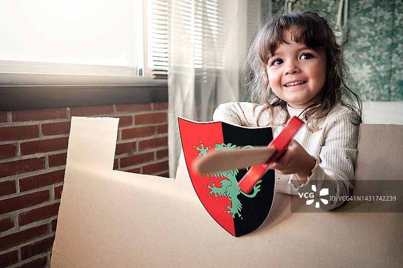 小女孩玩纸箱的乐趣图片素材