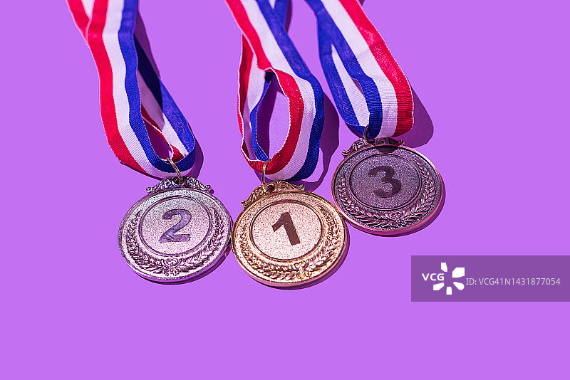 金银铜奖牌数字123紫色背景，胜利体育竞赛概念图片素材