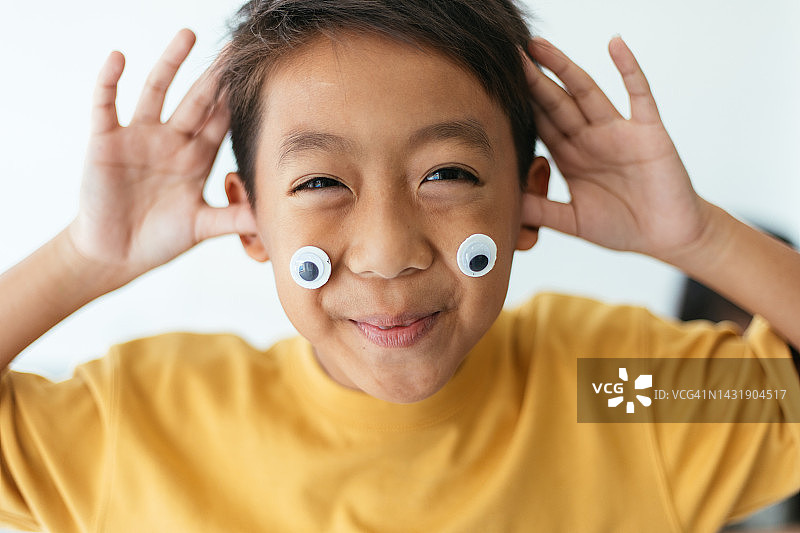 对着镜头做鬼脸的亚洲儿童图片素材