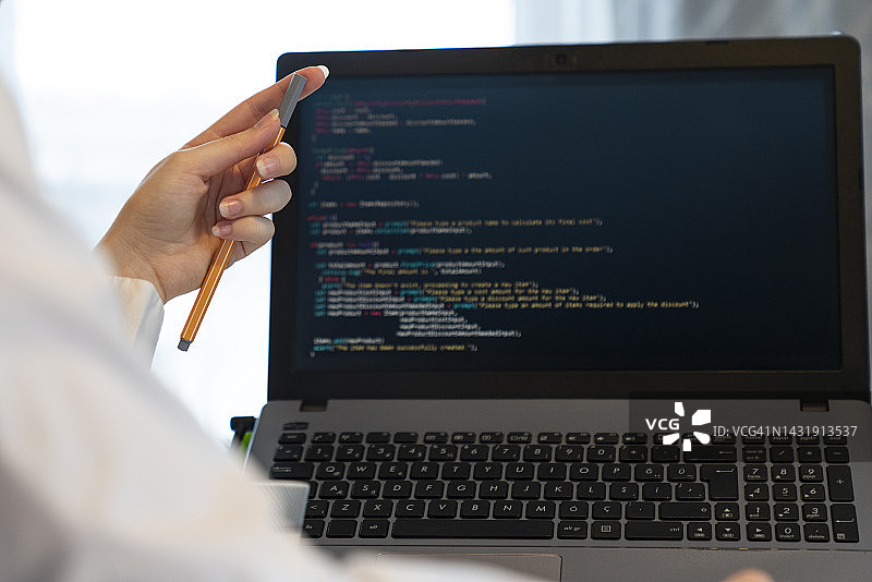 程序员在电脑显示器上编写代码（背面视角）图片素材