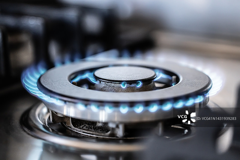 现代厨房炉灶的蓝色火焰特写图片素材