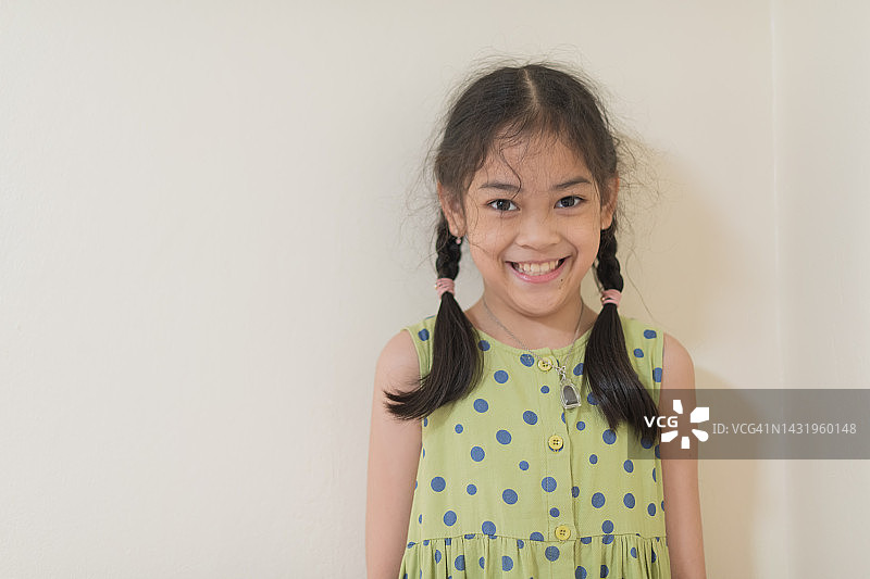 年轻的亚洲女孩面带微笑，看向镜头图片素材