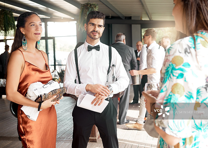 活动、婚礼或盛大聚会，一群穿着时尚、考究的宾客在享受交谈、倾听和发言。在奢华派对上交谈的人群和宾客。图片素材