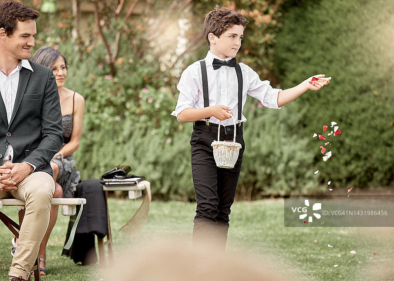 婚礼：花园里，花童在户外仪式上撒花瓣图片素材