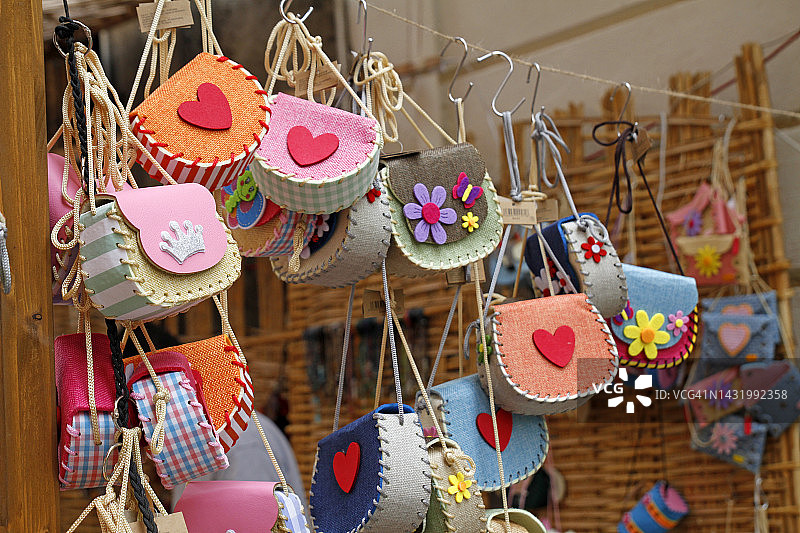 市场摊位上悬挂的彩色钱包图片素材