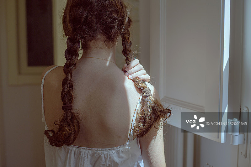 从背后看，拿着头发的少女图片素材